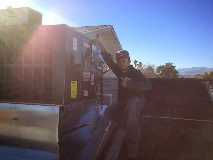 HVAC technician performing AC Tune-Up on a rooftop unit in El Paso